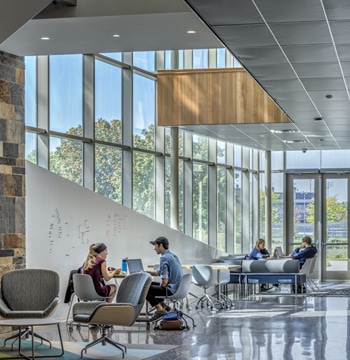 College students studying near windows in the De Witt Center for Science and Technology