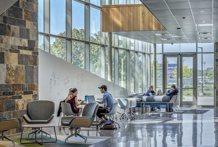 College students studying near windows in the De Witt Center for Science and Technology