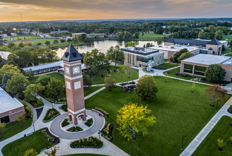 Aerial view of the Cornerstone University campus that shows academic buildings, bell tower and pond