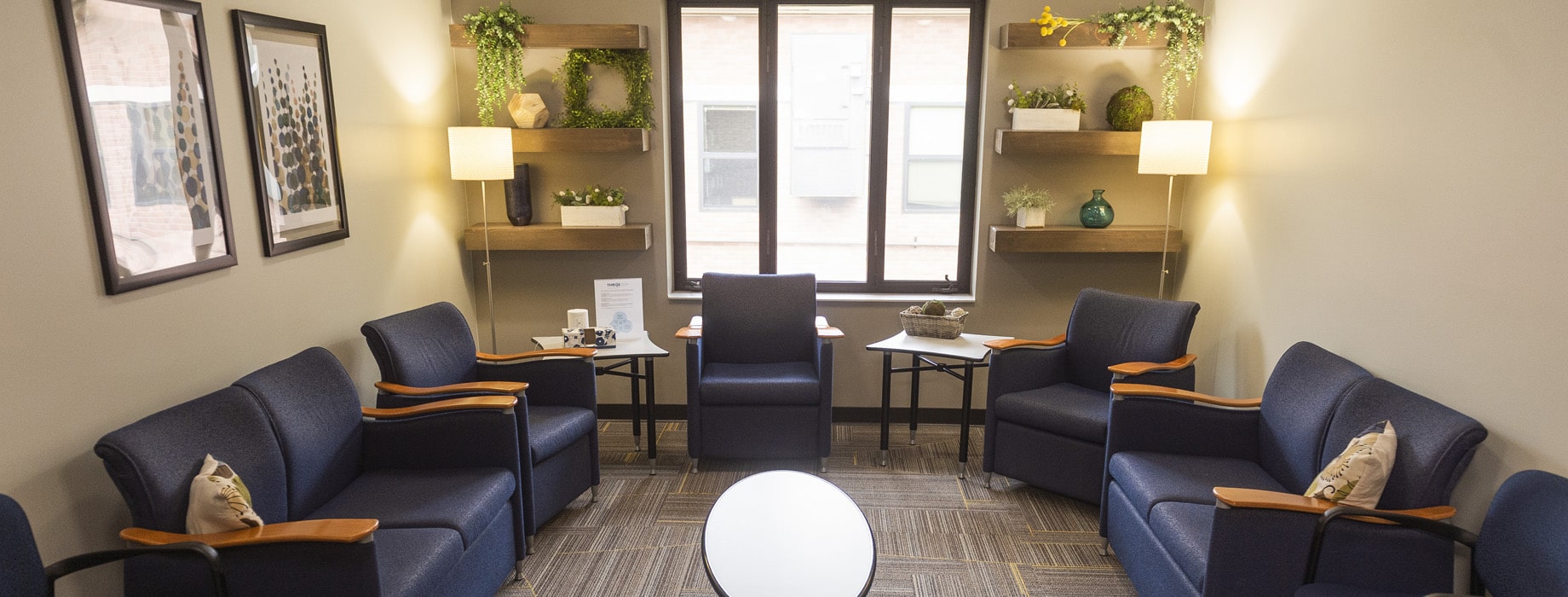The Well counseling services office with couches and chairs, a window and coffee table