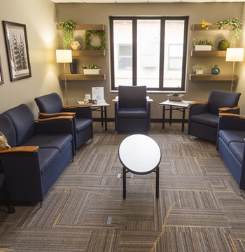 The Well counseling services office with couches and chairs, a window and coffee table