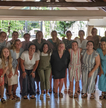 Cornerstone University women's volleyball team standing for a group photo in an open building structure in the Dominican Republic