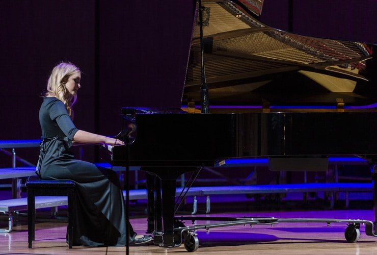 Female college student playing a grand piano in Matthews Performing Arts Center at Cornerstone University