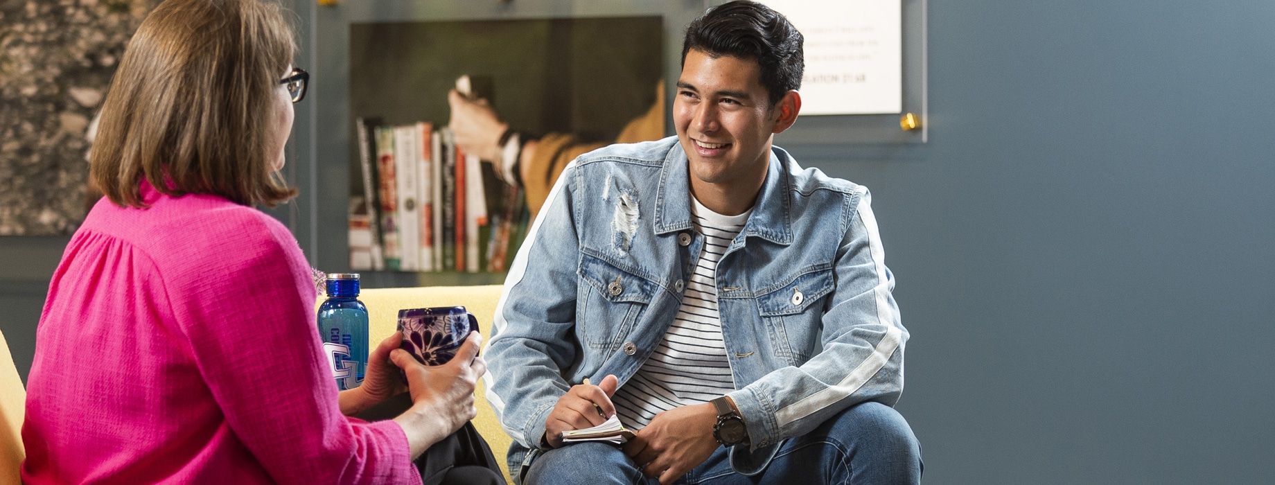 Male college student sitting across from a female staff member in the lobby of the Center for Student Success at Cornerstone University