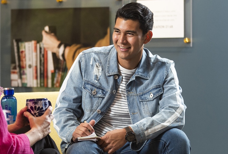 Male college student sitting across from a female staff member in the lobby of the Center for Student Success at Cornerstone University
