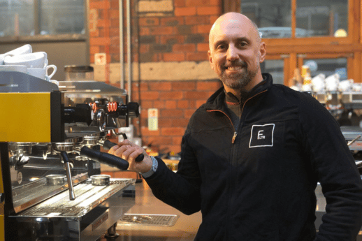 Jeff Lothamer standing in front of an expresso machine in a coffee shop