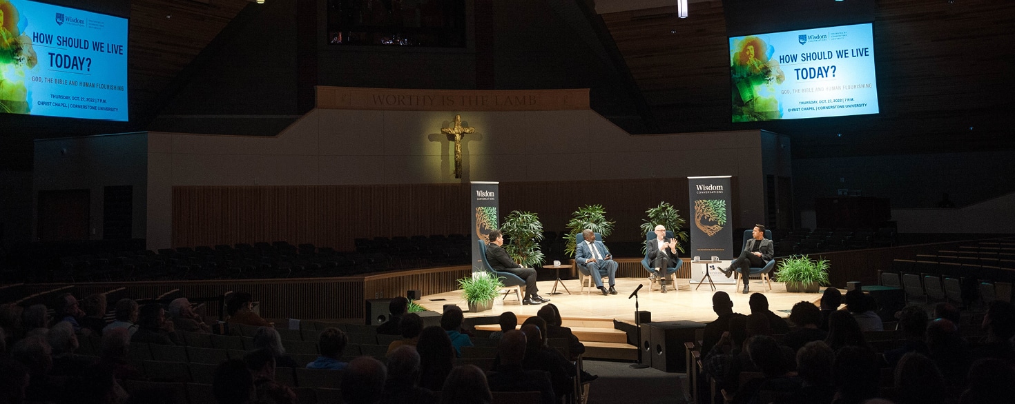 President Moreno-Riaño, Ian Rowe, Miroslav Volf and Samuel Rodriguez sitting on chairs in Christ Chapel while having a discussion in a front of an audience