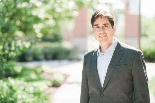 Dr. Michael Pasquale standing on sidewalk in front of Cornerstone University's Welch Clock Tower