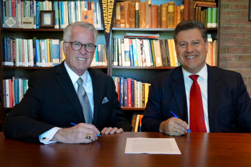 Chair of the Board of Trustees Dr. Richard Koole and Dr. Gerson Moreno-Riaño, president of Cornerstone University, sit at table in the President's Office for a contract renewal signing.