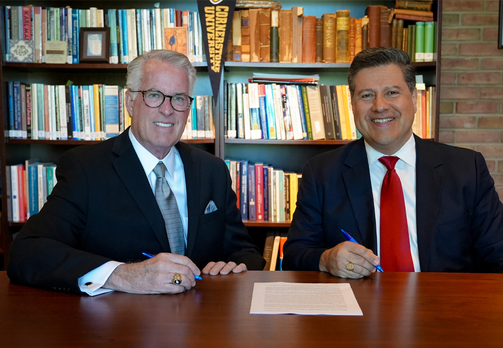 Chair of the Board of Trustees Dr. Richard Koole and Dr. Gerson Moreno-Riaño, president of Cornerstone University, sit at table in the President's Office for a contract renewal signing.