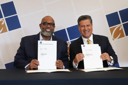 Project H.O.O.D. leader Pastor Corey Brooks and Cornerstone University President Gerson Moreno-Riaño display the signed Golden Eagle Partnership agreement during a signing ceremony at Cornerstone University