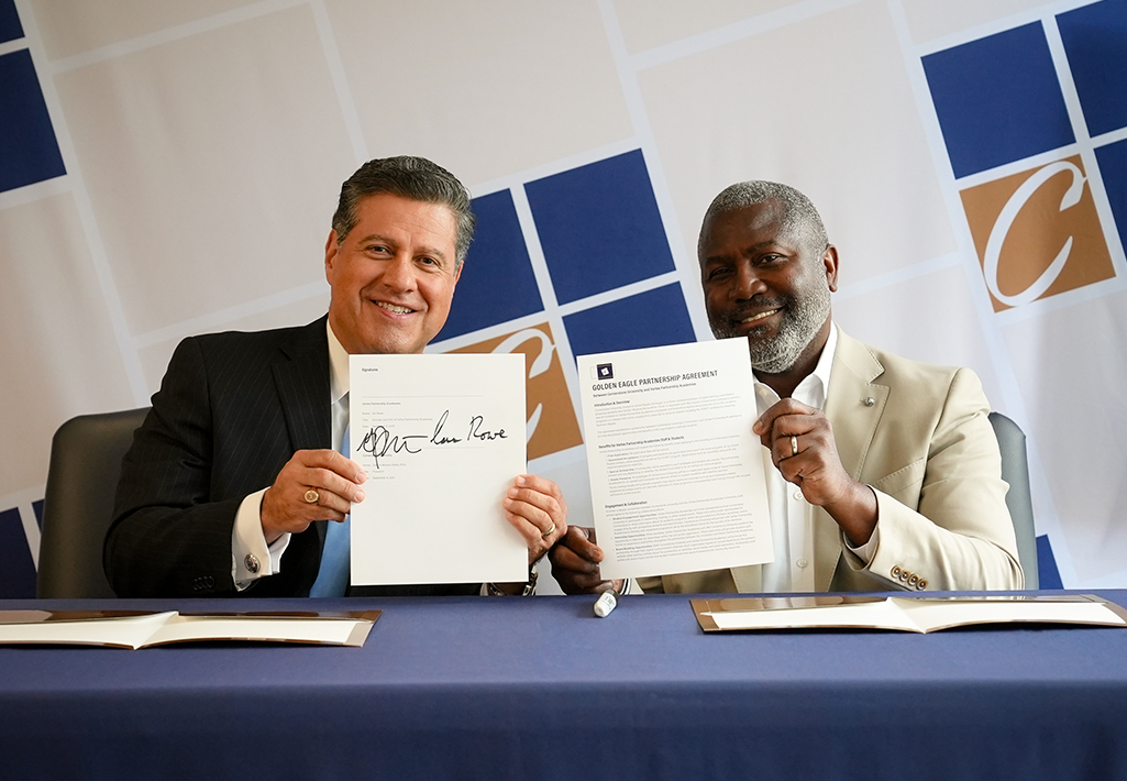 Cornerstone University President Gerson Moreno-Riaño and Ian Rowe, co-founder of Vertex Partnership Academies, hold up signed partnership agreement document between Cornerstone University and Vertex Partnership Academies