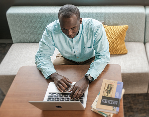 Student researching bible on computer