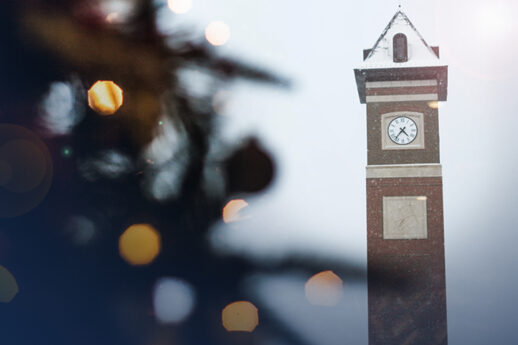 Cornerstone University bell tower in the falling snow with a Christmas tree in the foreground