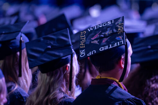 Graduates stand with mortarboards turned toward the camera, one reading Lifted Up on Eagle's Wings!, during Cornerstone University's 84th Commencement on Saturday, May 9, 2026